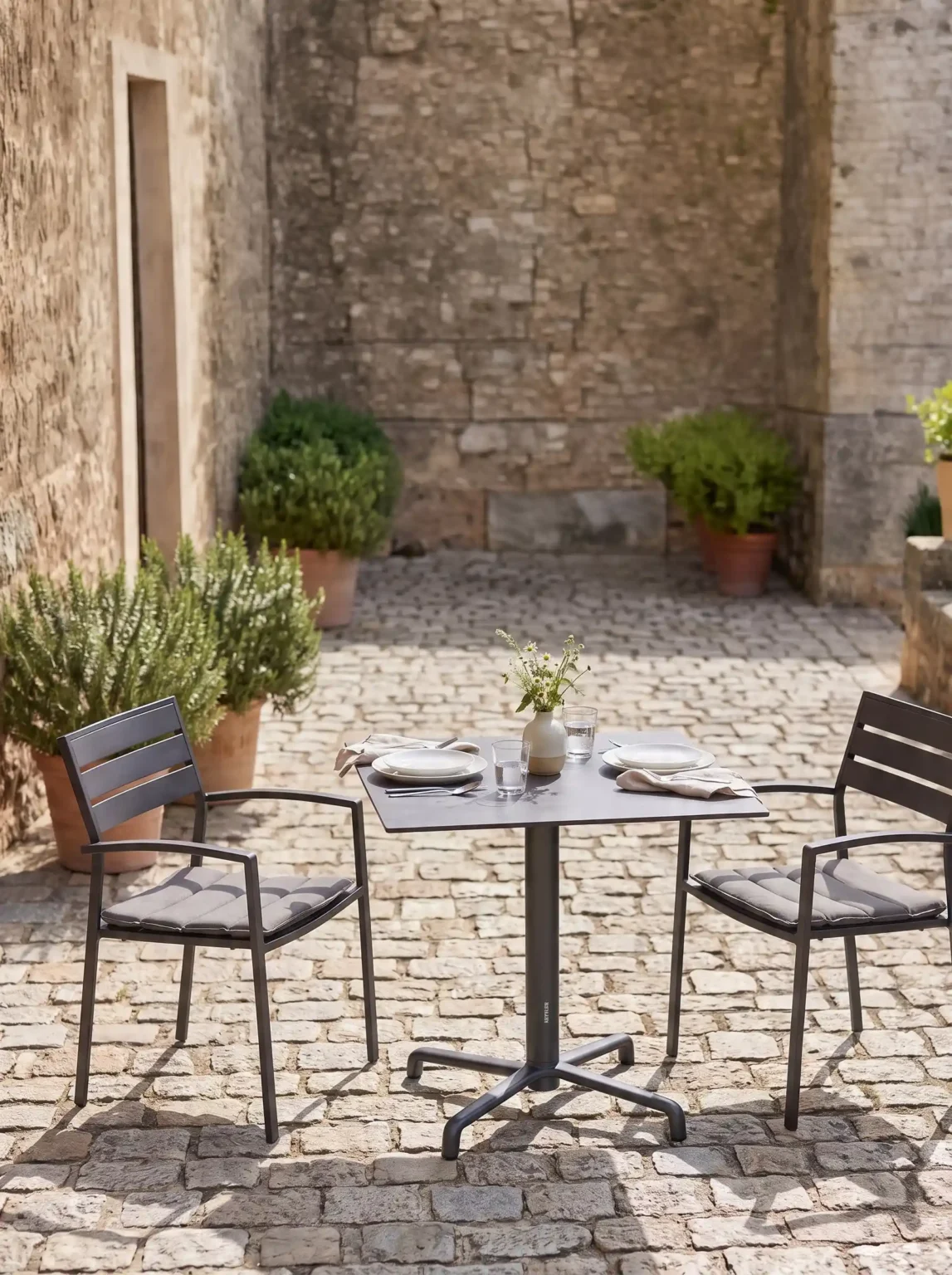 Kettler lifestyle image: bistro table with two chairs in a courtyard